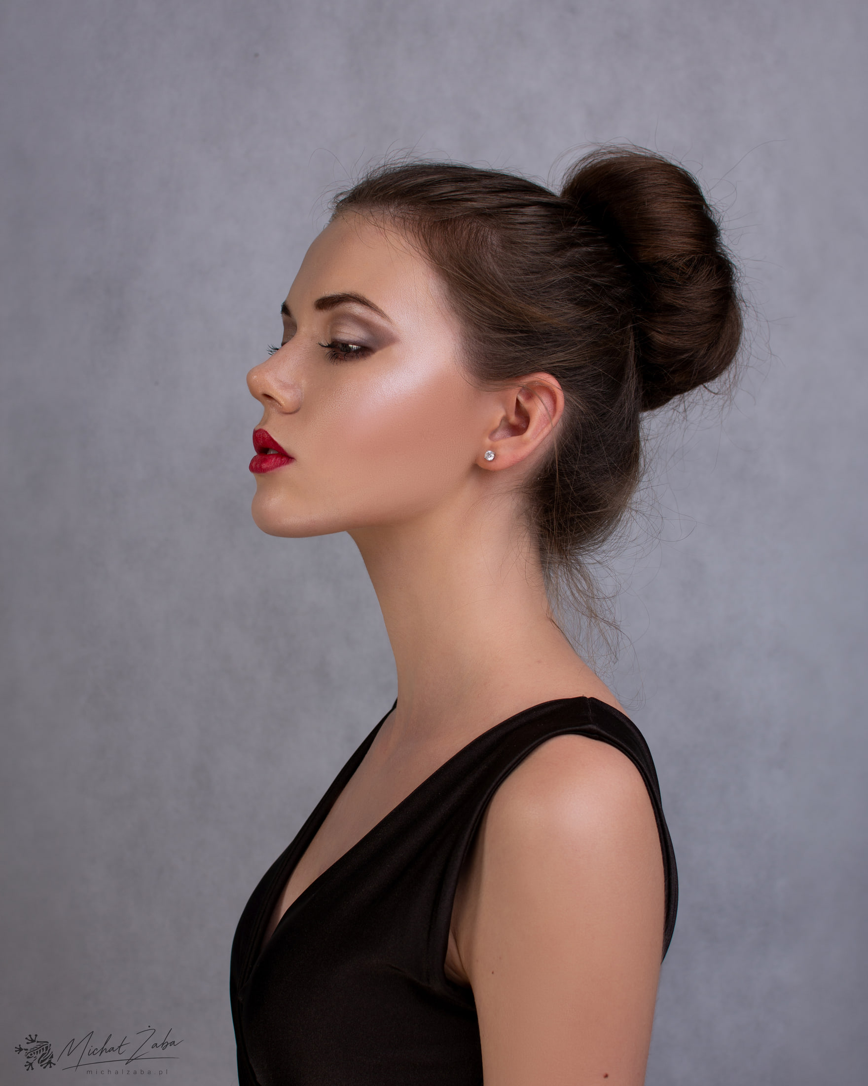 Portret Emilki z profilu na szarym tle — fotografia Michała Żaby