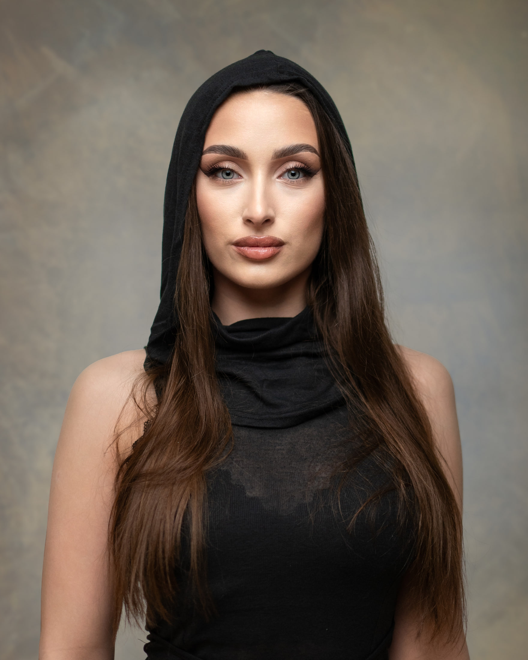 Portret kobiety w czarnej stylizacji na neutralnym tle — fotografia Michała Żaby